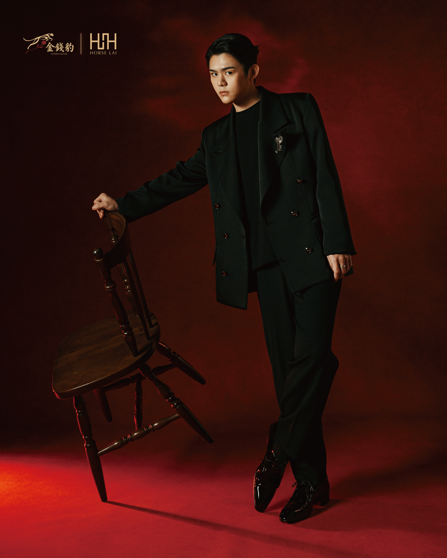 HORSE LAI 設計總監賴名浩於聯名形象拍攝中演繹黑色雙排扣西裝造型，以俐落剪裁與象徵性胸針細節展現品牌經典與當代結構並存的設計語彙，呼應此次與金錢豹合作所形塑的高端場域識別。